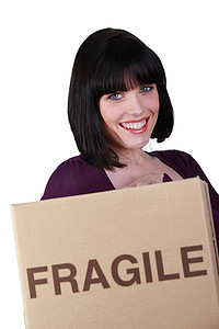 服装水洗标符号摄影照片_女人拿着一个标有易碎品的盒子