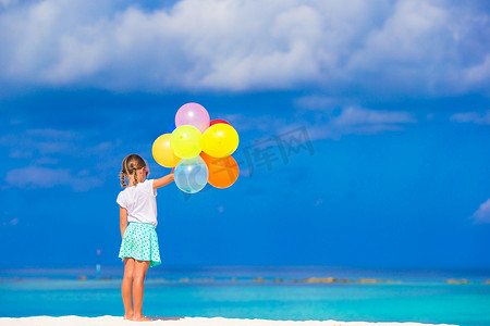 可爱的小女孩在沙滩上玩气球