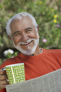 一个拿着咖啡杯和报纸的快乐老人的画像