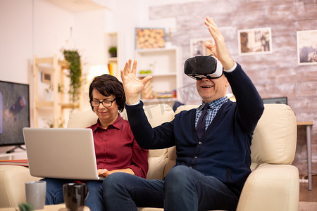 在他们舒适的公寓里使用 VR 虚拟现实耳机的退休老人