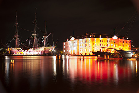 荷兰阿姆斯特丹：在 2013 年 12 月 30 日的年度阿姆斯特丹灯节上，建筑和带灯的古船。阿姆斯特丹灯节是冬季灯节
