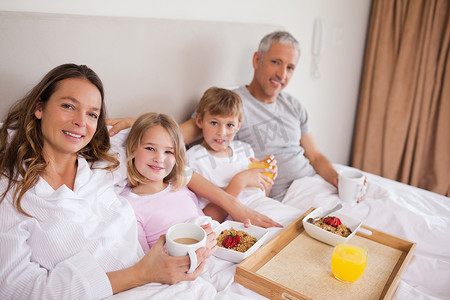 1011年摄影照片_幸福的家庭在卧室里吃早餐