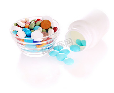 红色碟子摄影照片_白色瓶子和碟子，上面有多种颜色的药丸