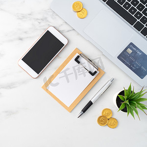 财务办公摄影照片_使用信用卡、智能手机、办公桌上的笔记本电脑查看财务计划概念。