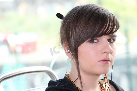 戴耳机的学生摄影照片_坐在电车上戴耳机的女孩特写