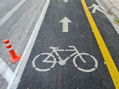 塞萨洛尼基摄影照片_有黄色分隔线的新的都市运输自行车道在柏油路旁边。