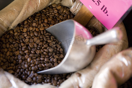 咖啡价格标签摄影照片_一袋带金属勺的咖啡豆
