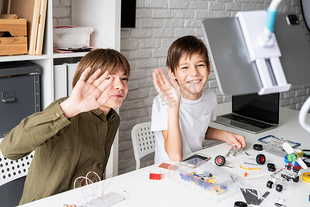 在数字平板电脑上在线上课的小男孩玩得开心制作机器人汽车