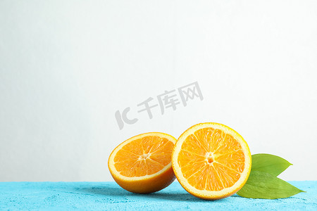 一半橙色，蓝色桌子上有叶子，白色背景，文字空间