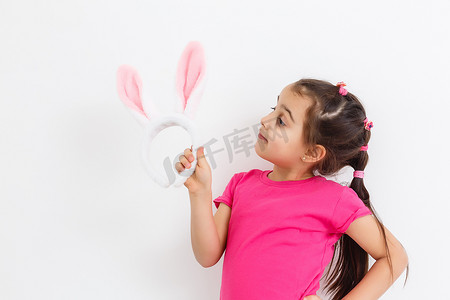 戴着滑稽兔子耳朵的快乐掉牙小女孩
