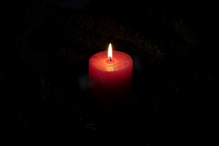 带有红色燃烧蜡烛和深色背景的圣诞主题