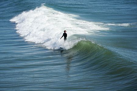 橘子州摄影照片_在美国加利福尼亚州圣地亚哥北部的欧申赛德享受巨浪的男性冲浪者。