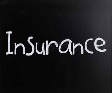 用白色粉笔在黑板上手写的“保险”一词