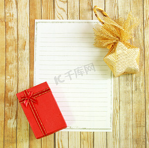 礼物盒制作摄影照片_木制背景上带有空白便条纸的礼物盒和星星