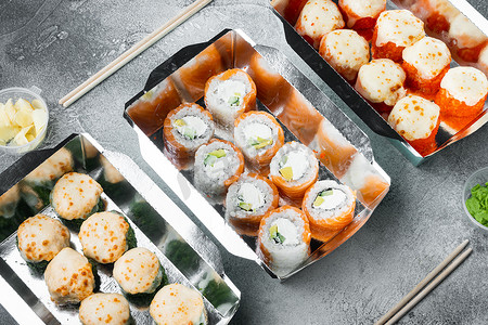 灰石背景中送餐盒中的一组寿司卷