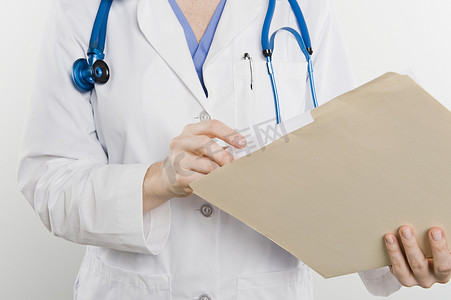 一位女医生的中段，其医疗档案在白色背景下被隔离