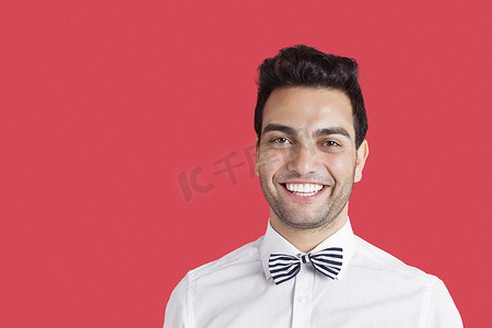 红色背景中戴着领结的快乐中年男子的画像