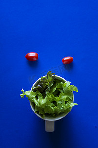 蓝色背景杯中的蔬菜，极简主义摄影