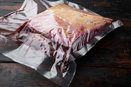 用塑料包装切割的顶级沙朗牛肉，在旧木桌上，有文字复制空间