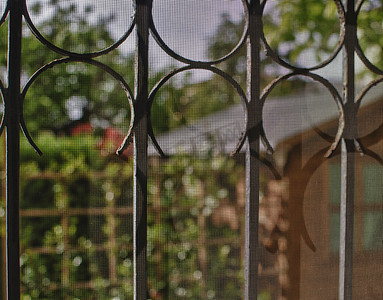 从带格栅的窗户看到的庭院和花园