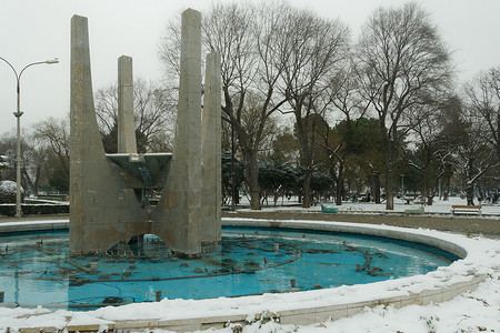 塞萨洛尼基摄影照片_停止在市中心降雪期间不工作的喷泉。