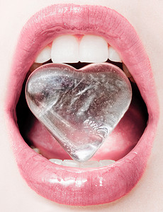护心摄影照片_冰冷的心脏、有光滑的唇膏的女性嘴唇和洁白的牙齿