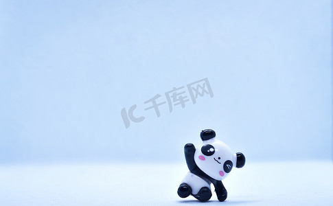 孤立在黑色背景上的小熊猫瓷雕像