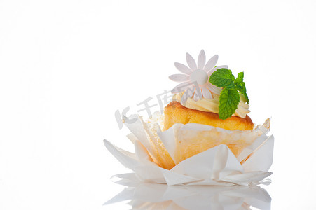白色纸杯蛋糕，上面有香草奶油薄荷叶和糖花