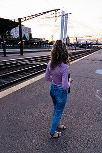 少女独自走在火车站台上，在火车站拍照
