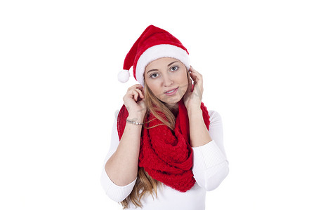 圣诞帽围巾摄影照片_戴着红围巾和圣诞帽的年轻漂亮女人