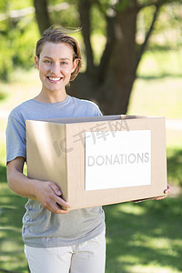 志愿者中摄影照片_公园里的快乐志愿者拿着盒子