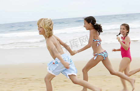欢快的小朋友在沙滩上一起跑步的侧视图