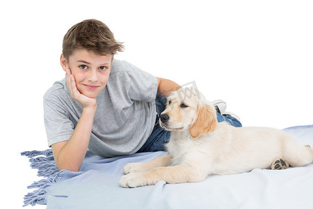 男孩和狗玩耍摄影照片_男孩和狗躺在毯子上