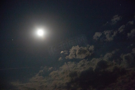 有云彩和蒙着面纱的月亮的夜空
