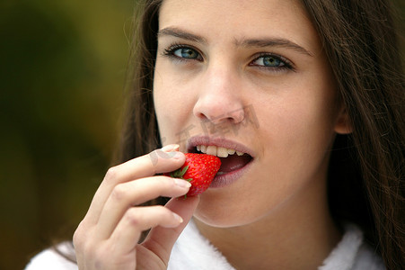 可口草莓摄影照片_吃可口草莓的浅黑肤色的男人