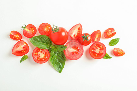 平铺组合物，白色背景上有新鲜的樱桃西红柿和罗勒，文字空间。