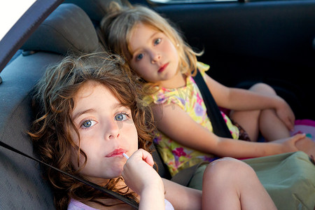 小孩儿吃东西摄影照片_车内吃糖棒的小女孩