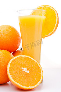 一堆橙子靠近一杯橙汁