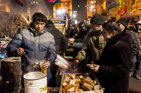 抗议者摄影照片_Maidan - 活动家给抗议者送汤和面包