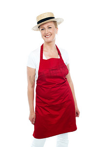 佩带红色围裙和帽子的可爱的女性厨师
