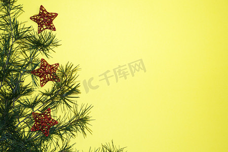 新年黄色背景上的针叶树枝和圣诞树装饰，复制空间