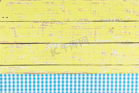 黄色木桌面背景纹理，带有质朴的蓝色桌布