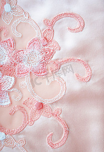 花朵花边背景摄影照片_优雅的粉红色丝绸上的花朵蕾丝