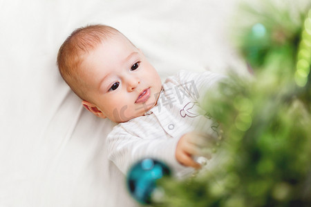 躺在圣诞树下的男婴或女婴。