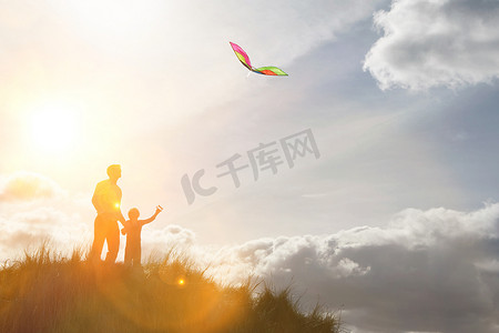 父母带着孩子在山顶玩风筝