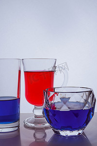 白色背景上不同玻璃杯与多色液体的组合