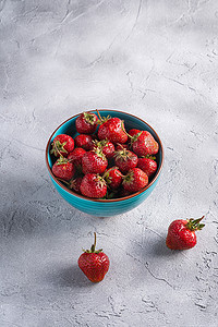 蓝碗中新鲜成熟的草莓果实，夏季维生素浆果