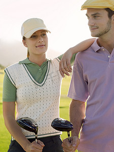 有男性朋友的年轻女性高尔夫球手在高尔夫球场