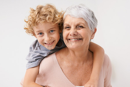 背驮式、肖像和祖母与孩子的拥抱，在墙壁背景下快乐而亲密。