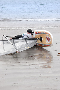 风帆冲浪者在沙滩上休息